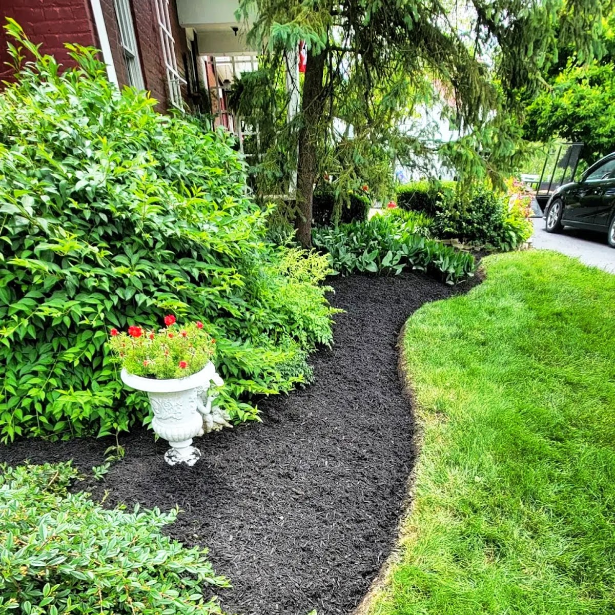 Fresh black mulch garden bed with a clean lawn edge
